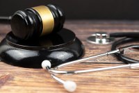 A photo of a gavel resting next to a stethoscope.
