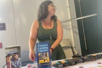A photo of a woman standing at a table with gun safety pamphlets.